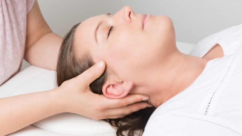 Chiropractor performing gentle cervical adjustment to help relieve vertigo and improve balance.